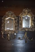 Two antique bevelled glass mirrors having filigree gilt edging and integrated candlestick holders.
