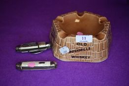 A vintage Old Bushmills Whiskey ashtray and two pen knives/multi tools,one having spoon and fork.