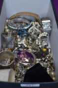 A box of costume jewellery including wrist watches, bangles, necklaces, white metal napkin rings