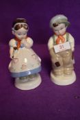 A pair of Royal Dux figures of a Shcool boy and girl