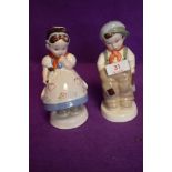 A pair of Royal Dux figures of a Shcool boy and girl