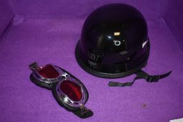 A AHP cycle helmet and pair of motor style goggles