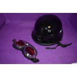 A AHP cycle helmet and pair of motor style goggles