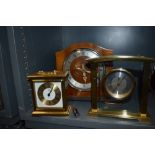 An art deco mantle clock and two similar brass bodied mantle clocks