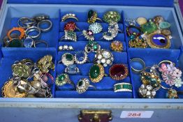 A jewellery box containing a large selection of costume jewellery rings of various designs