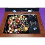A musical jewellery box containing a small selection of costume jewellery necklaces