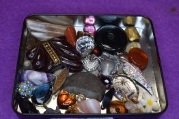 A small selection of costume jewellery including horn scarf ring, glass discs, polished stones,