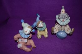 A Lladro figurine, Having A Ball 5813 along with two Nao figurines of Young Jesters