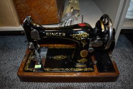 An antique Singer sewing machine and a selection of knitting needles,model number Y7411251.
