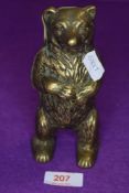 A vintage brass money box in the form of a bear.