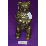 A vintage brass money box in the form of a bear.