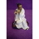 A vintage Chinese figure of a man playing instrument in a mudman style signed Wan Jiang to base