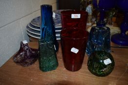 A collection of colourful art glass vases and similar.