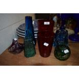 A collection of colourful art glass vases and similar.