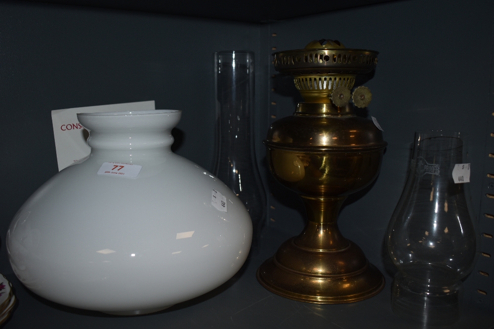 A brass bodies oil lamp with milk glass shade