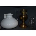 A brass bodies oil lamp with milk glass shade