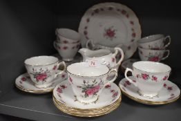 A collection of vintage cups, saucers,cake plate and more, having pink rose pattern and gilt