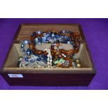 A treen jewellery box having monogram HD to lid, containing a small selection of costume jewellery