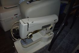 A sewing machine in hard case by Neechin