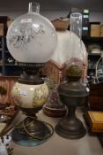 A vintage oil lamp, a desk lamp in the form of an oil lamp and a ceramic lamp with floral pattern