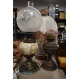 A vintage oil lamp, a desk lamp in the form of an oil lamp and a ceramic lamp with floral pattern
