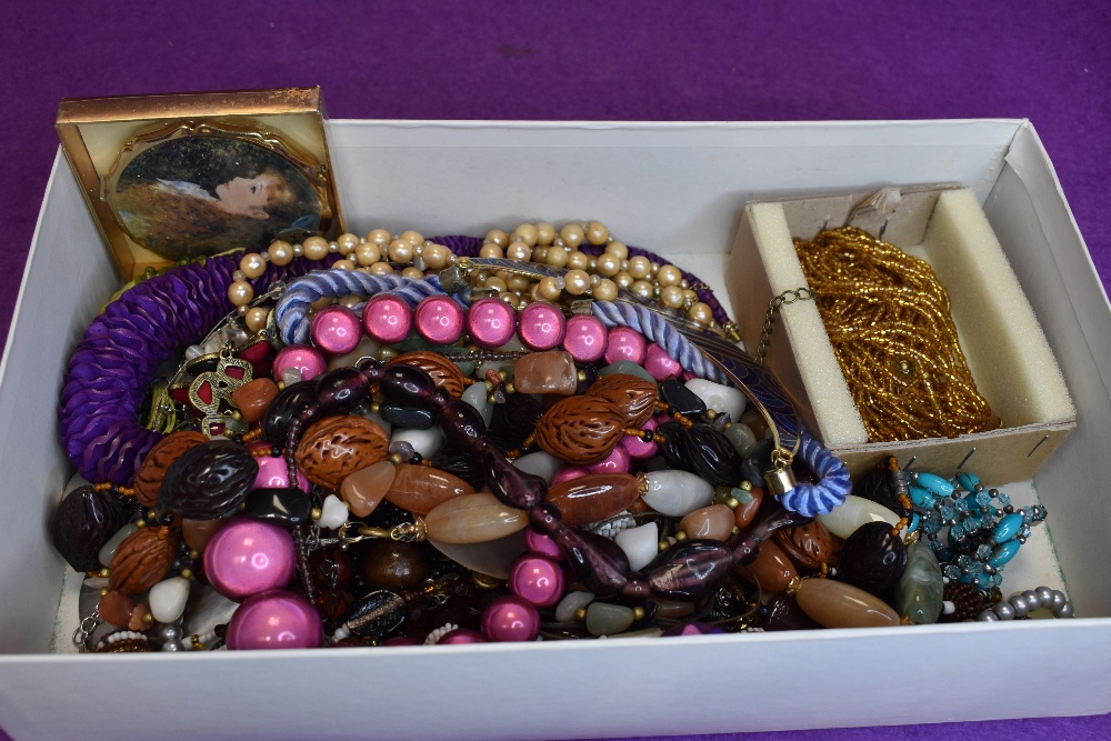 A box of costume jewellery necklaces of various forms and a powder compact