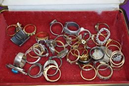 A small travel jewellery case containing a selection of costume jewellery rings of various forms