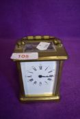 A brass cased French carriage clock having visible escape gallery and enamel face dials