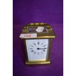 A brass cased French carriage clock having visible escape gallery and enamel face dials