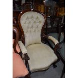 A traditional nursing chair having carved mahogany frame work with button back upholstery