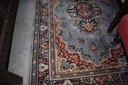 A carpet rug having pale blue ground with floral boarder