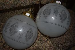 A pair of etched glass globe light fittings having brass gallery