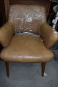 A 70's style office arm chair in beige tan vinyl