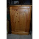 A modern natural pine corner cupboard