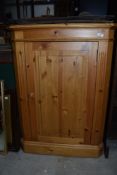 A modern natural pine corner cupboard