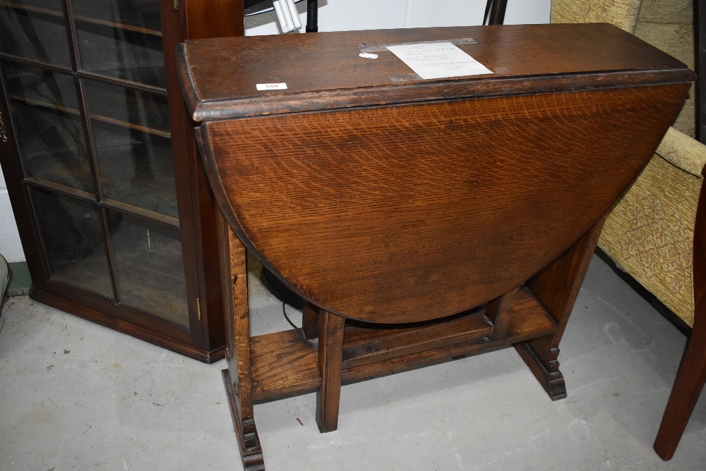 An early 20th Century oak gateleg table with linen fold detailing to end panels