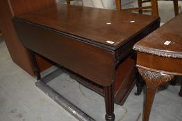 A Victorian mahogany Pembroke style dining table, having fluted legs and brass castors, in the