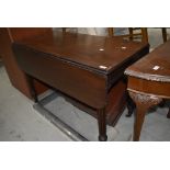 A Victorian mahogany Pembroke style dining table, having fluted legs and brass castors, in the