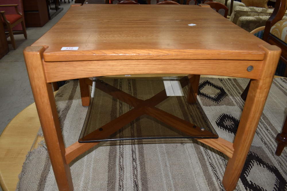 A modern Ercol square coffee table having glass undershelf
