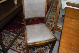 A set of four early 20th Century oak dining chairs having late upholstered seats (with fire labels)