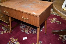 A vintage teak side table, previously housing a sewing machine, on dansette style legs