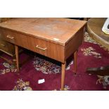 A vintage teak side table, previously housing a sewing machine, on dansette style legs