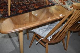 A light Ercol extending dining table having double centre leaf (Grand Windsor) and a set of six (