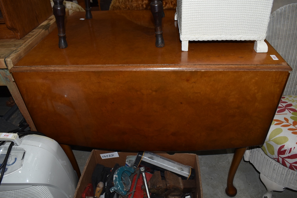 A drop leaf dining table having maple veneer top and shaped legs