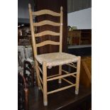 A beech framed ladder back chair having rush seat