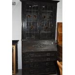 A 19th Century dark oak Jacobean style bureau bookcase, black forest and arts and crafts influences