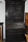 A 19th Century dark oak Jacobean style bureau bookcase, black forest and arts and crafts influences