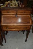 An Edwardian mahogany and inlaid bureau on tapered legs with spade feet