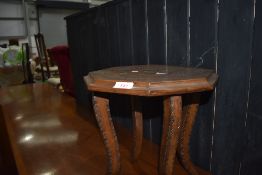 A hand carved small table with an Indian theme