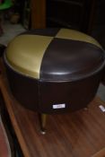 A mid century atomic style foot stool in vinyl